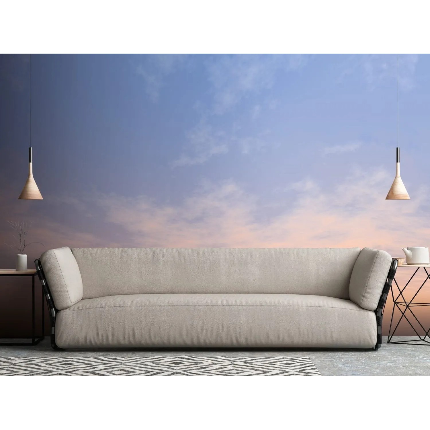 Fototapete Wolken in Blau, Weiß und Grau hinter einem Sofa. Romantische Vliestapete für Wohnzimmer.