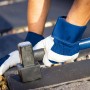 Hände mit LUX Arbeitshandschuhen aus Leder beim Pflastern mit Hammer.