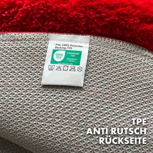 Rutschfeste Rückseite der roten, runden KARAT Badematte SKY (95 cm) mit Öko-Tex Standard 100 Label.
