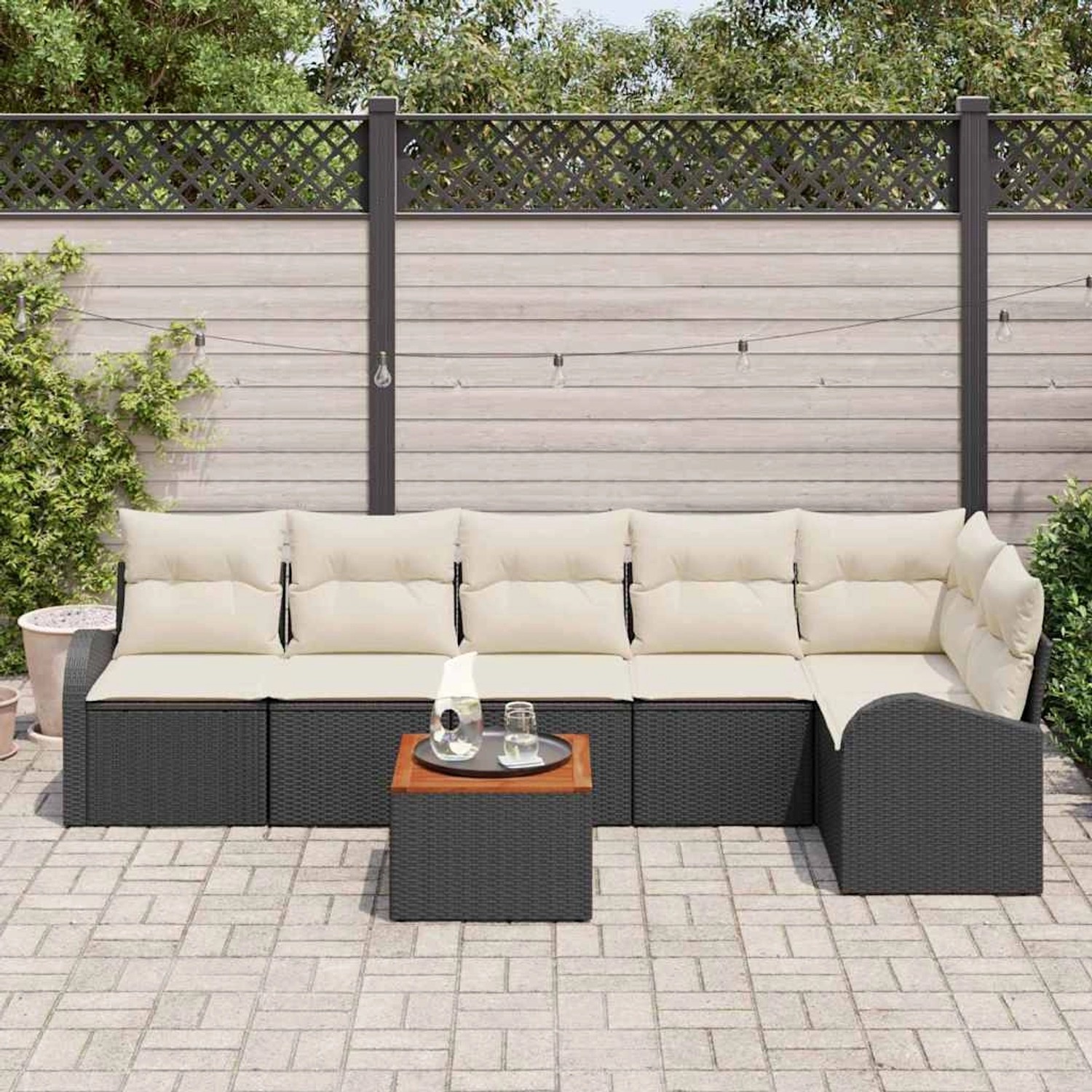 Schwarzes vidaXL Garten-Sofa-Set, 7-teilig, mit weißen Kissen und Tisch auf einer Terrasse.