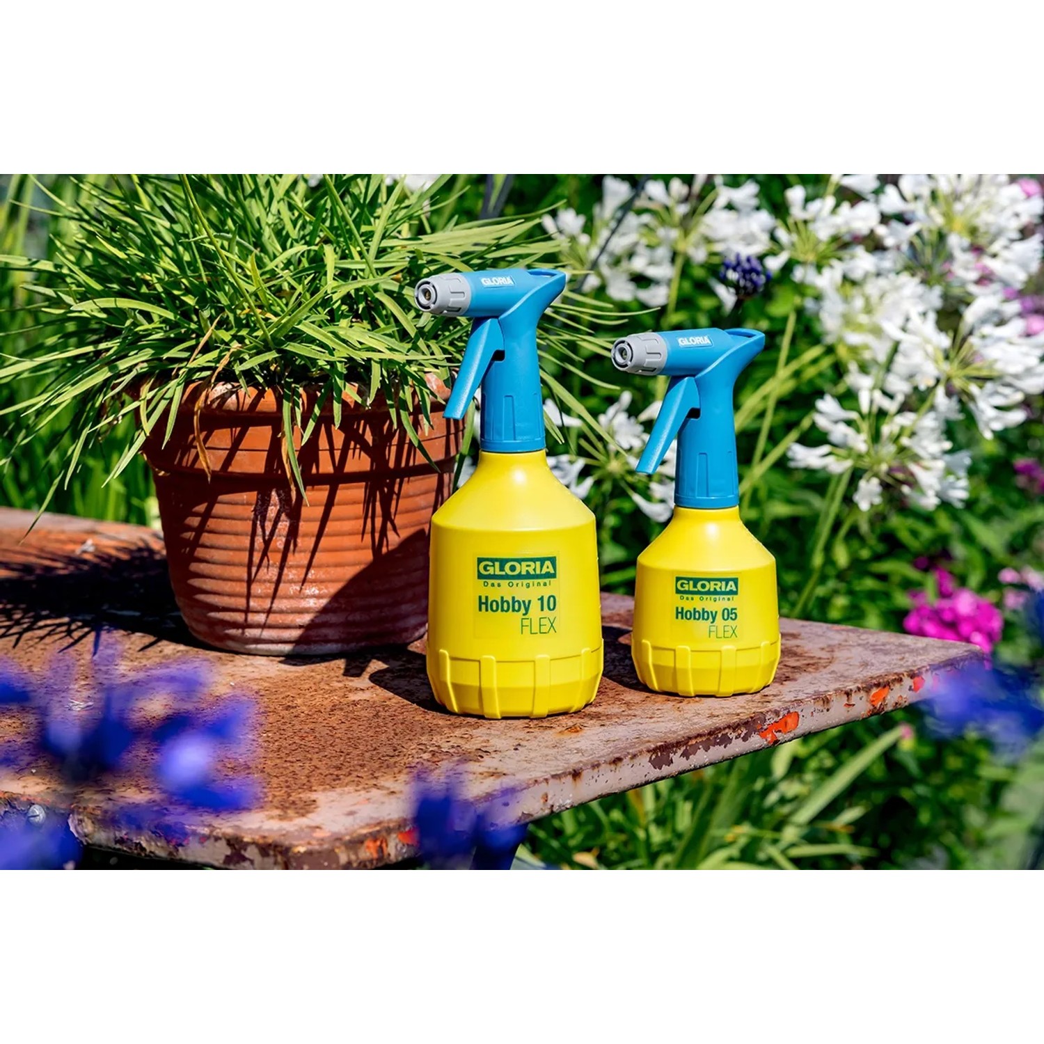 Gloria Hobby 10 Flex und Hobby 05 Flex Feinsprüher, gelb/blau, vor Pflanzen.