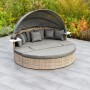 Merxx Relaxinsel Riva Premium: Runde Lounge-Gartenmöbel mit Dach, Kissen und Ablagetischen.