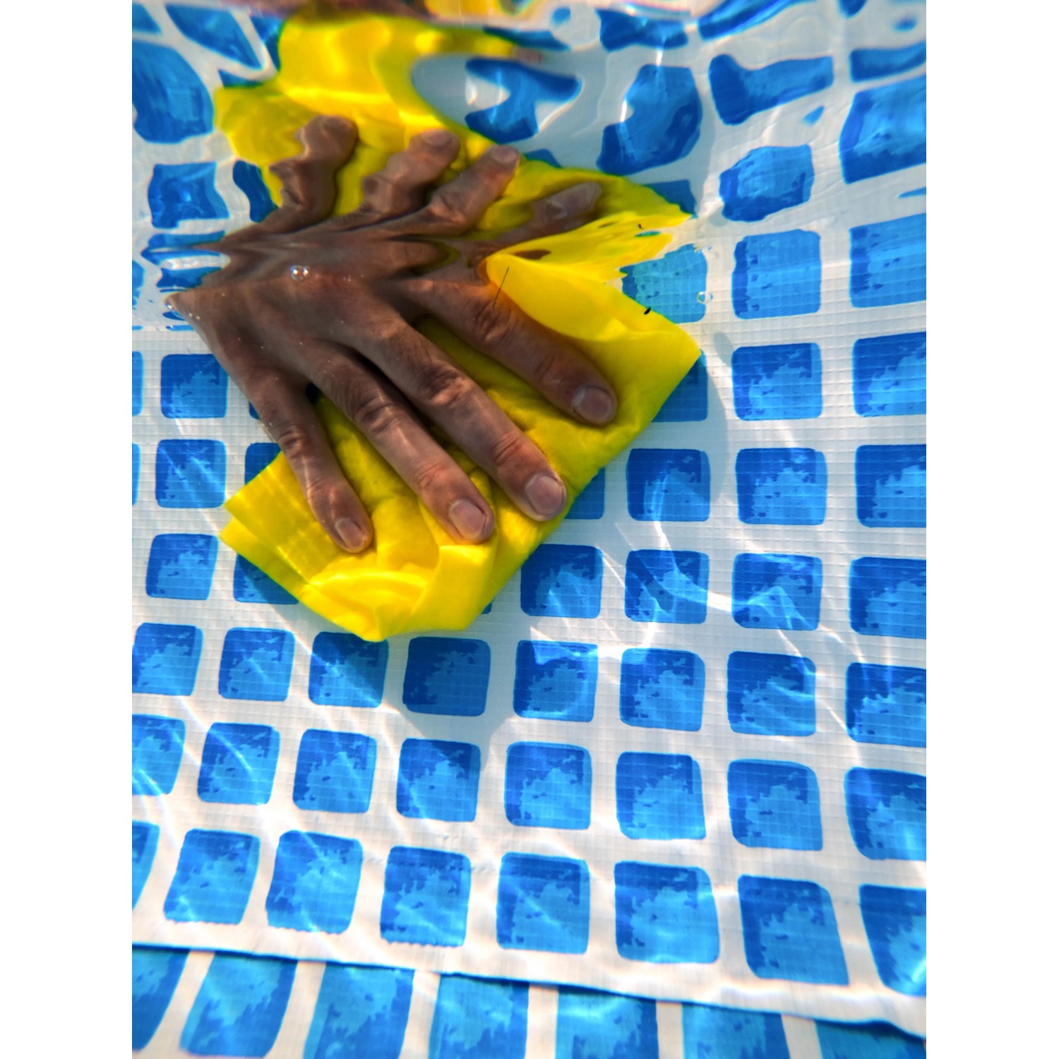 Anwendung von transparentem T-Rex Waterproof Tape unter Wasser auf Poolfolie.