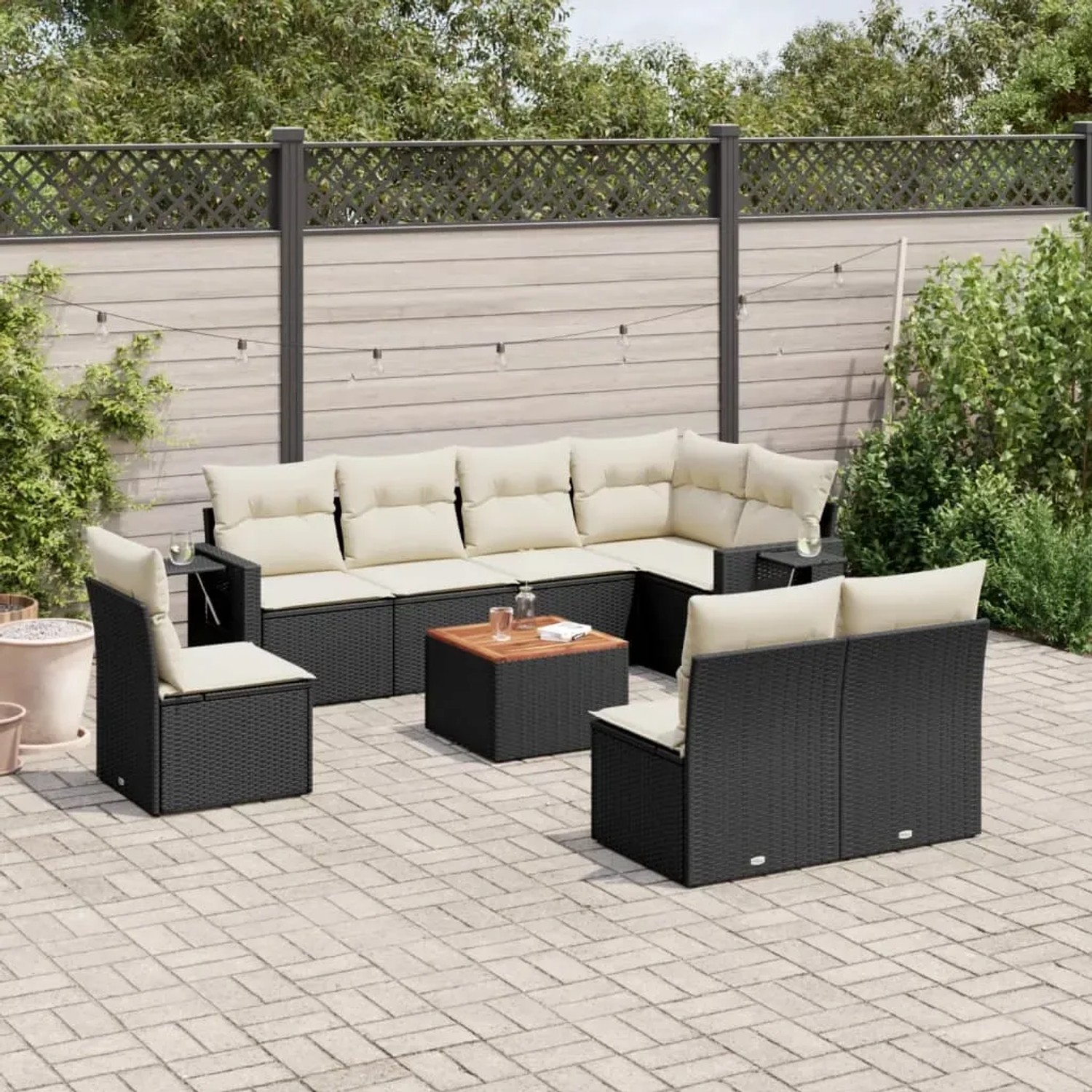 Schwarze 9-tlg. Garten-Sofagarnitur aus Polyrattan mit cremefarbenen Kissen und Holztisch.