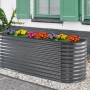 Anthrazitfarbenes Floraworld Hochbeet Welle (240x80x82cm) aus Metall, bepflanzt mit bunten Blumen.