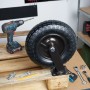 Schwarze luftbereifte Lenkrolle aus Stahl für Schwerlast, 360° drehbar, auf Holz mit Werkzeug. Ideal für Transportwagen.