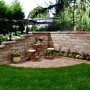 Gartenansicht mit Bruchsteinmauer Jura-Nuanciert als Grundstücksbegrenzung und Sitzecke.