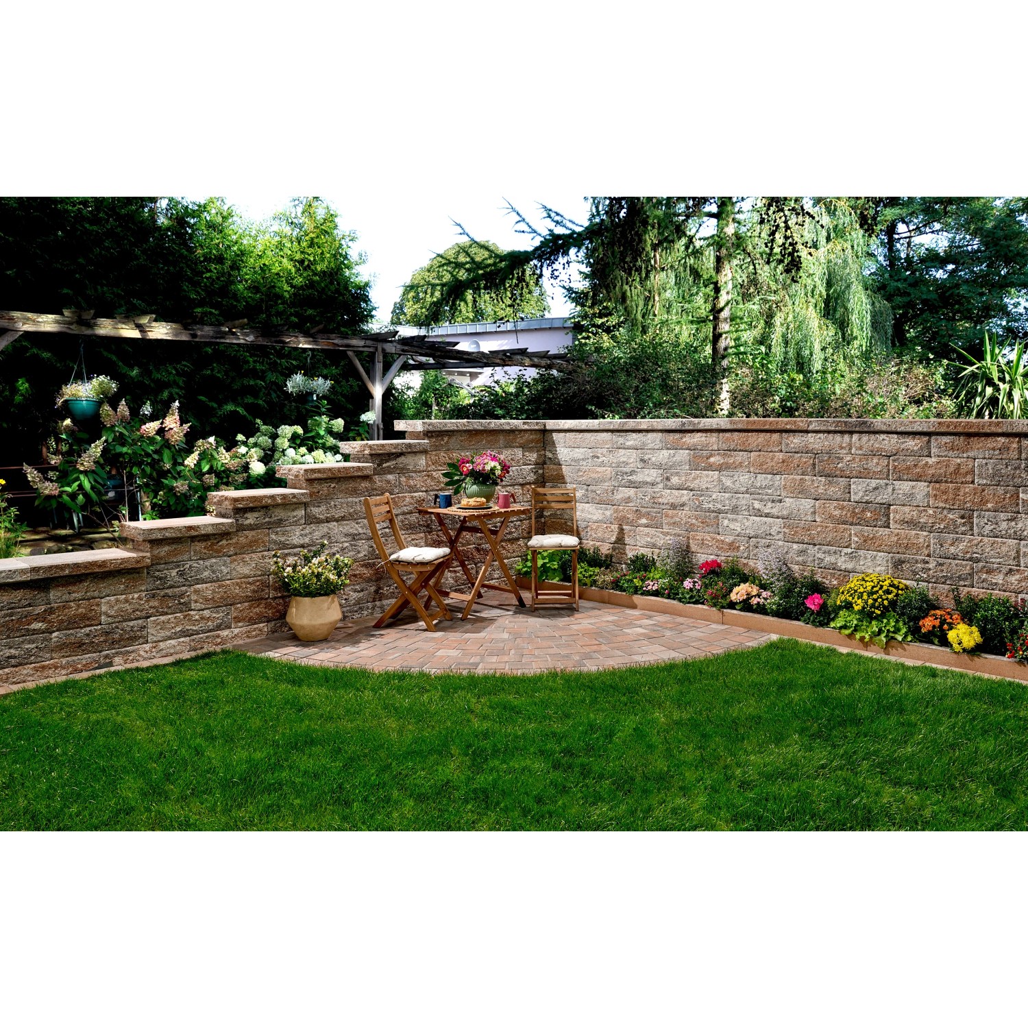 Gartenansicht mit Bruchsteinmauer Jura-Nuanciert als Grundstücksbegrenzung und Sitzecke.