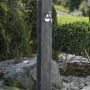 Arves Wasserzapfstelle Natura Black Granit im Garten mit Chromhahn.