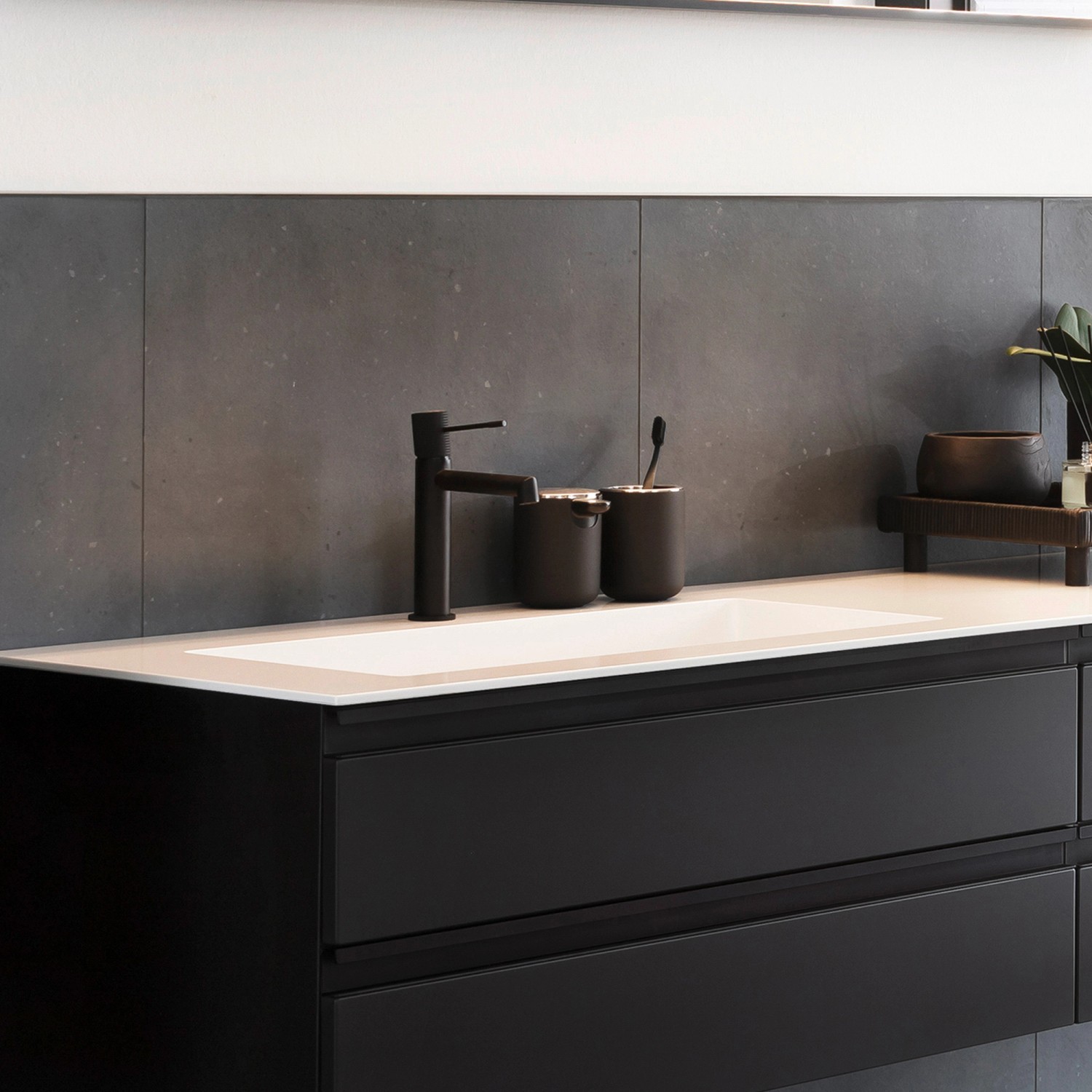 Schwarze Schöner Wohnen Waschtischarmatur Kadia mit mittelhohem Auslauf auf einem Waschtisch.