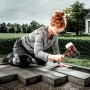 Frau verlegt Pflastersteine mit Halder Simplex Schonhammer (Ø 60mm) mit Gummi- und Superplastikeinsatz.