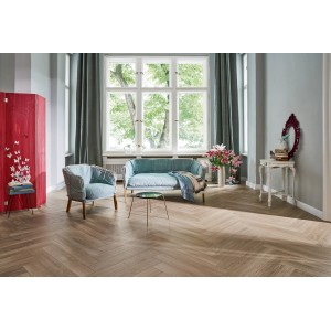 Wohnraum mit Parador Laminat Trendtime 3 Eiche Skyline Fischgrät Grau im Fischgrätmuster verlegt.