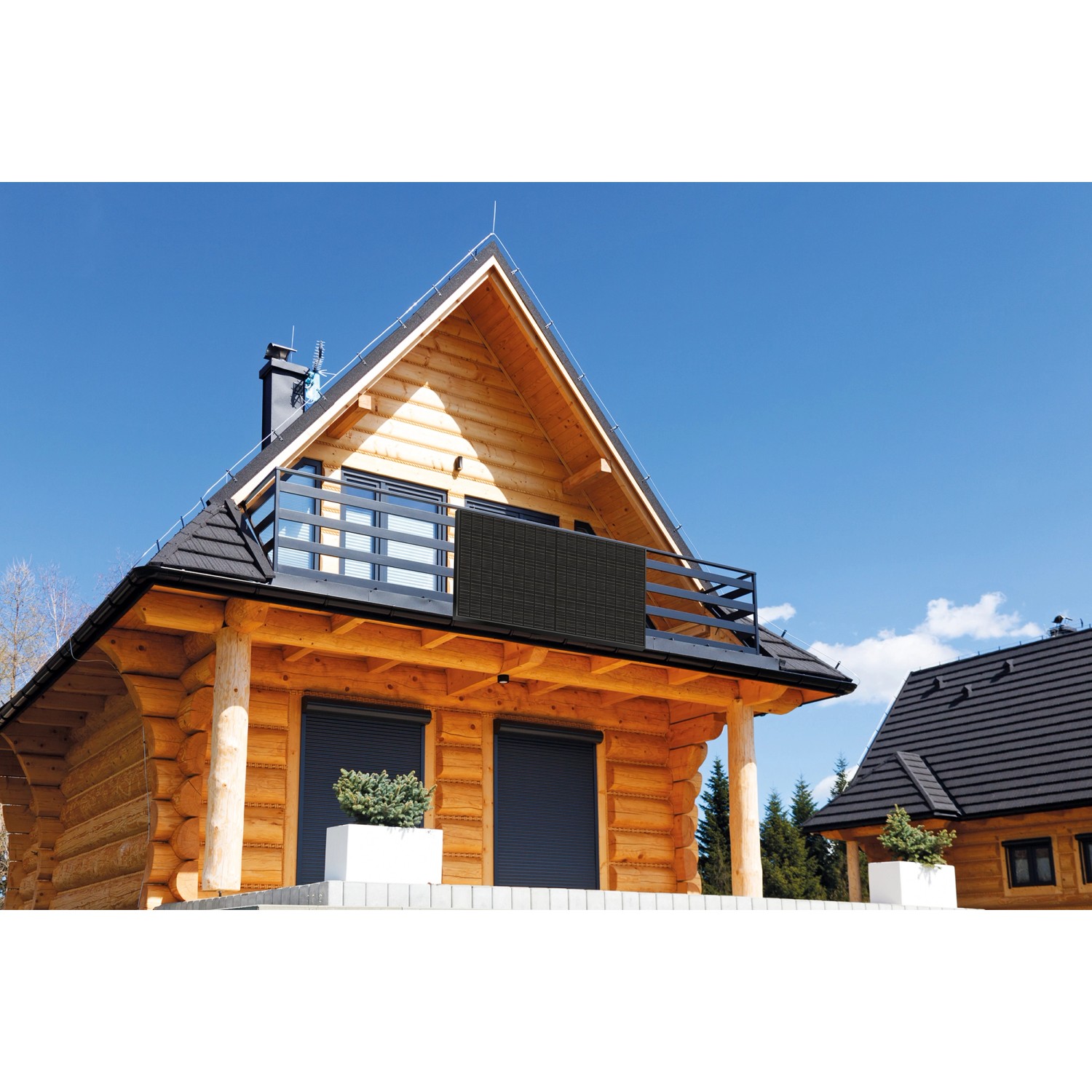 Schwaiger Solarmodul Full Black am Balkon eines Holzhauses unter blauem Himmel.
