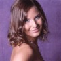 Lächelnde Frau mit braunen Haaren vor lila Walimex Pro Stoffhintergrund für Fotografie.