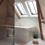 Beige Bambusblätter-Tapete von Origin Wallcoverings im Badezimmer mit Dachfenstern.
