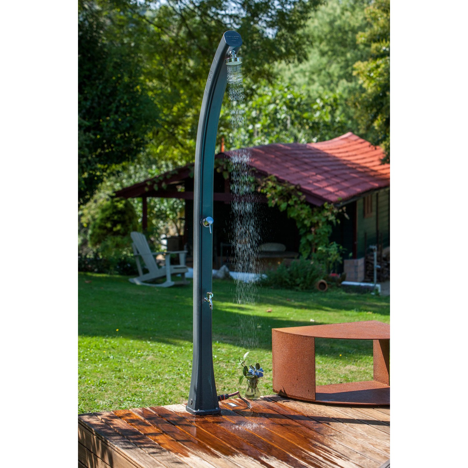 Gre Solardusche aus Harz, 25 l, Grau mit Fußwaschhahn in Gartenumgebung.