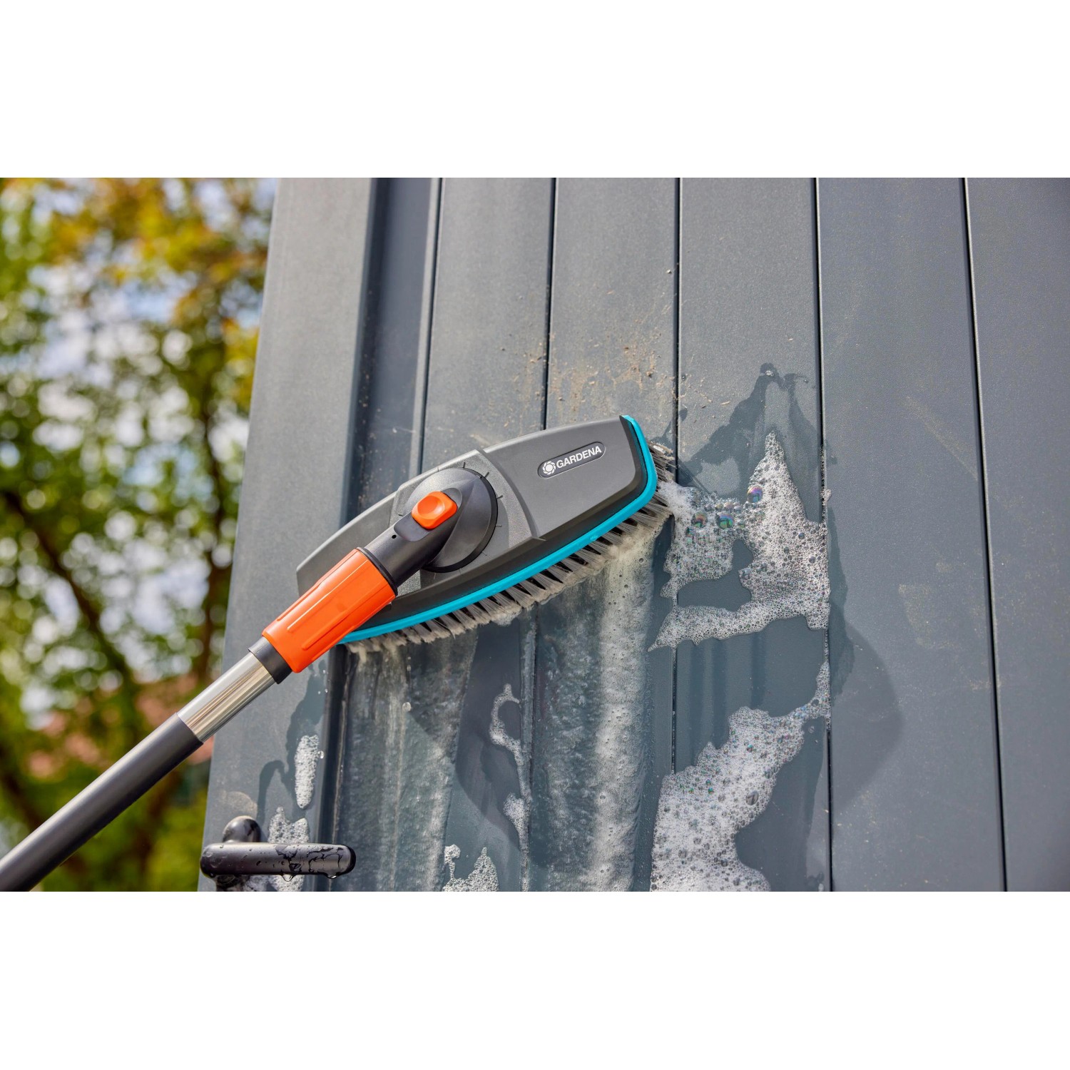 Gardena Cleansystem Stielbürste Soft in Anthrazit bei der Reinigung einer grauen Wand.
