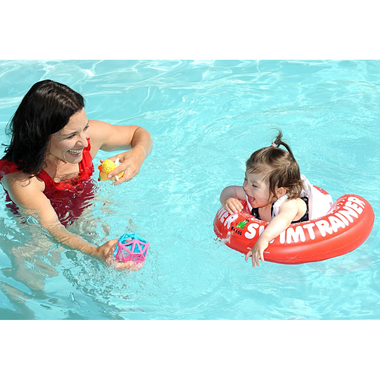 Kind mit rotem Freds Swim Academy Schwimmreifen im Pool mit Mutter.