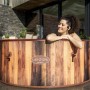 Runder LAY-Z-SPA Helsinki AirJet Whirlpool in Holzoptik mit Frau im Wasser.