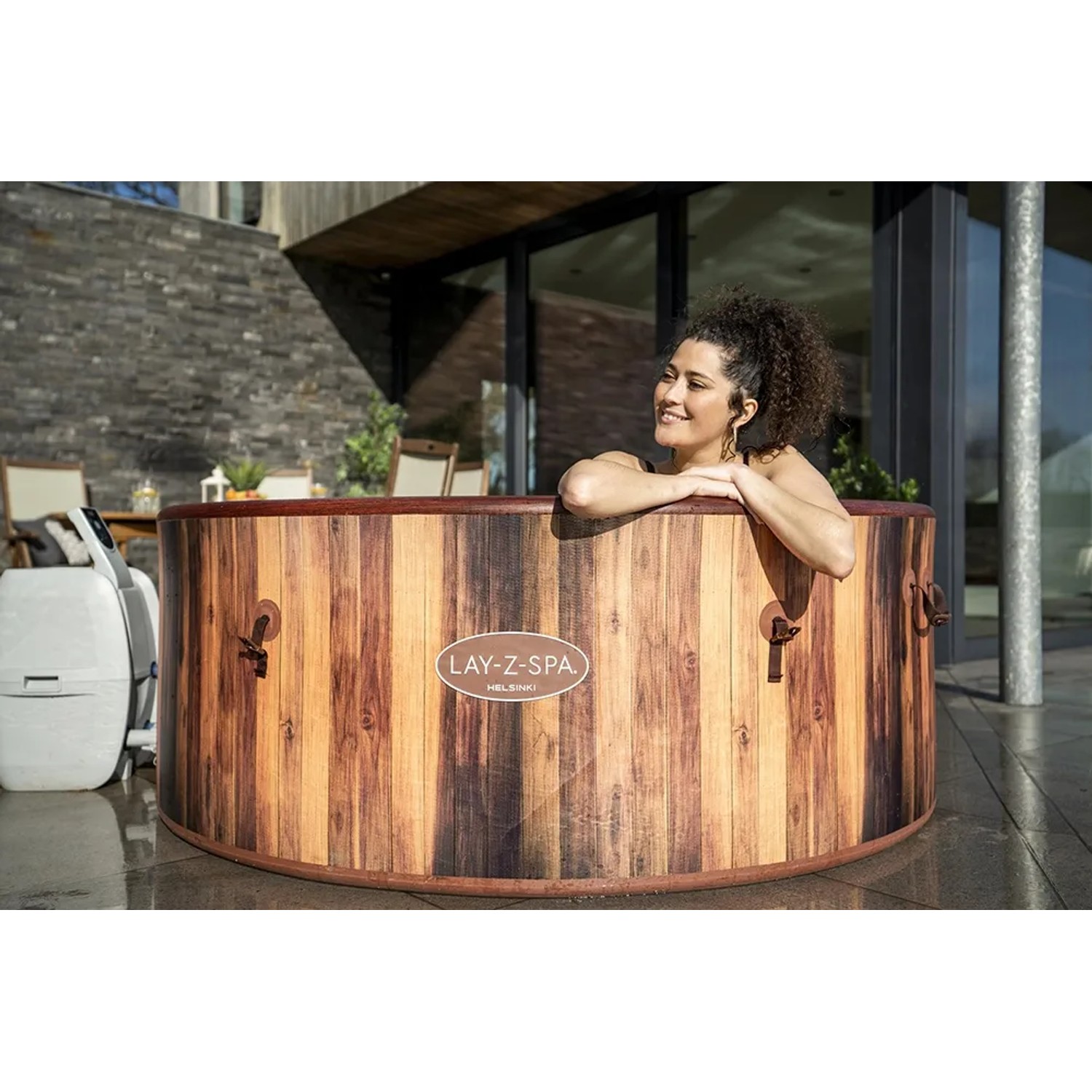 Runder LAY-Z-SPA Helsinki AirJet Whirlpool in Holzoptik mit Frau im Wasser.