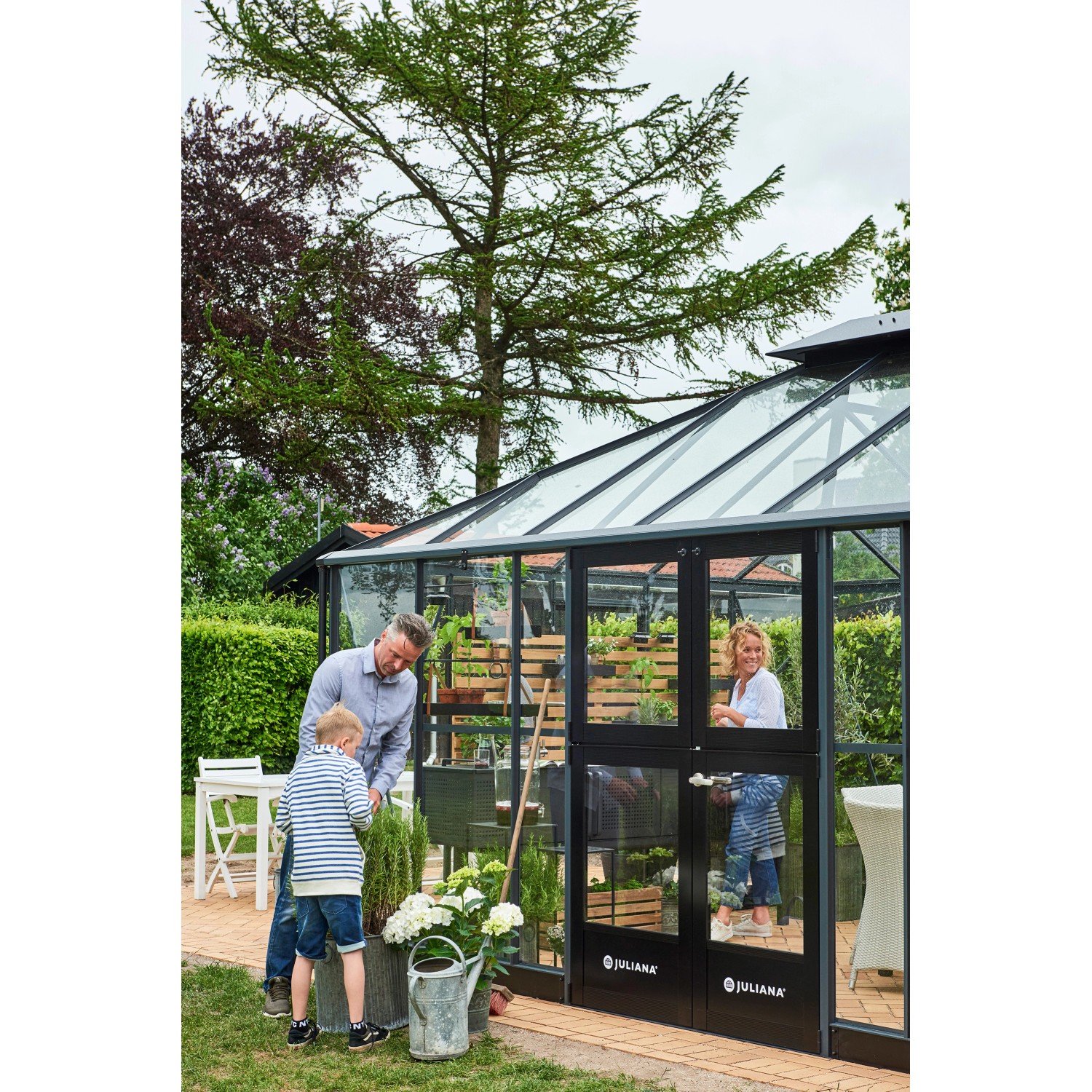 Juliana Gewächshaus Grand Oase 18, anthrazit-schwarz, mit Familie beim Gärtnern.