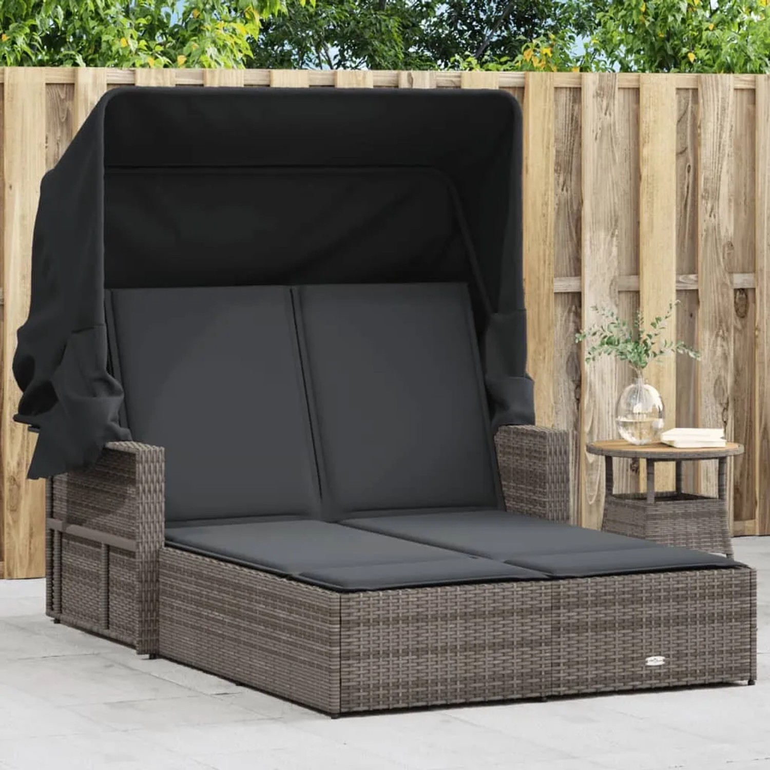 Graue Doppel-Sonnenliege aus Rattan mit Dach und Auflagen für den Garten.