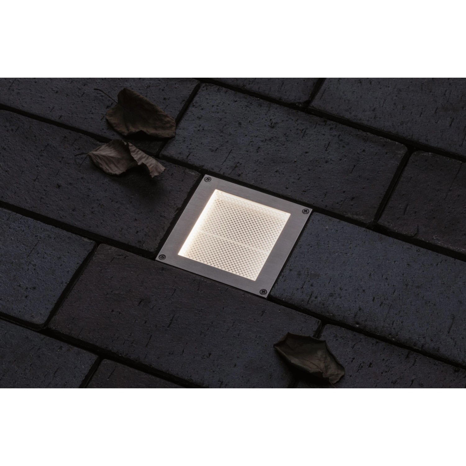 Quadratischer Paulmann LED Bodeneinbaustrahler Brick 10x10 cm im Pflasterstein auf dunklem Untergrund.