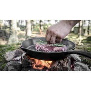 Petromax Grillpfanne Gusseisen 35cm mit Steak auf offenem Feuer. Grillutensil für Outdoor-Küche.