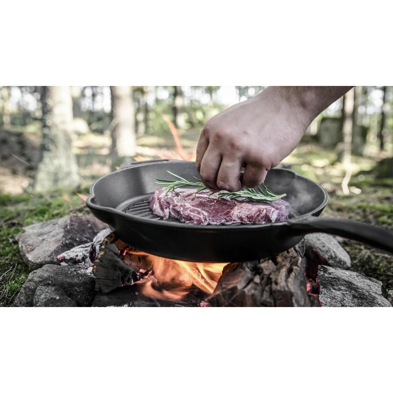 Petromax Grillpfanne Gusseisen 35cm mit Steak auf offenem Feuer. Grillutensil für Outdoor-Küche.