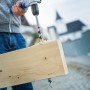 LUX Balkenbohrer Comfort bohrt Loch in Holzbalken mit Spänen.