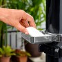 Detailaufnahme: Hand legt Seife in die Ablage der Bestway Solarflow Gartendusche.