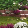 Beispielhafte Gartengestaltung mit braunen Kann Pflanzsteinen Mini Plus als Beetbegrenzung.