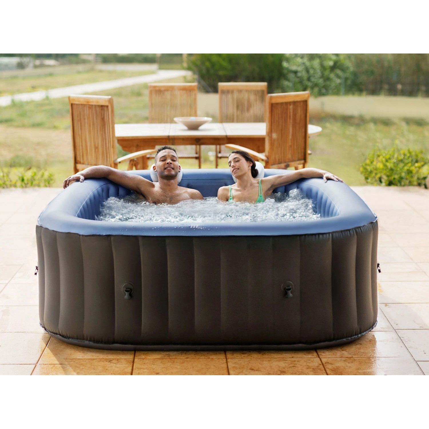 MSpa Comfort Tekapo AirJet Whirlpool mit Hydromassage, blau-schwarz, mit zwei Personen im Wasser.