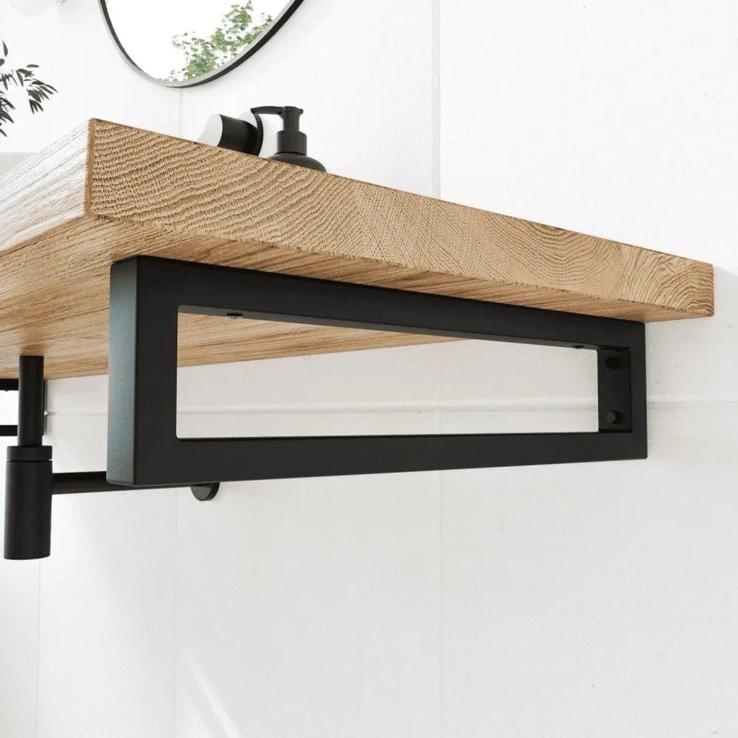 Schwarze HEVVA RHEIN Waschtischhalterung aus Metall unter Holzplatte an weißer Wand für modernes Bad.