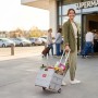 Frau zieht hellgrauen Relaxdays Einkaufstrolley mit Teleskopgriff und Einkäufen vor Supermarkt. Klappbarer Einkaufswagen aus Kunststoff/Alu.