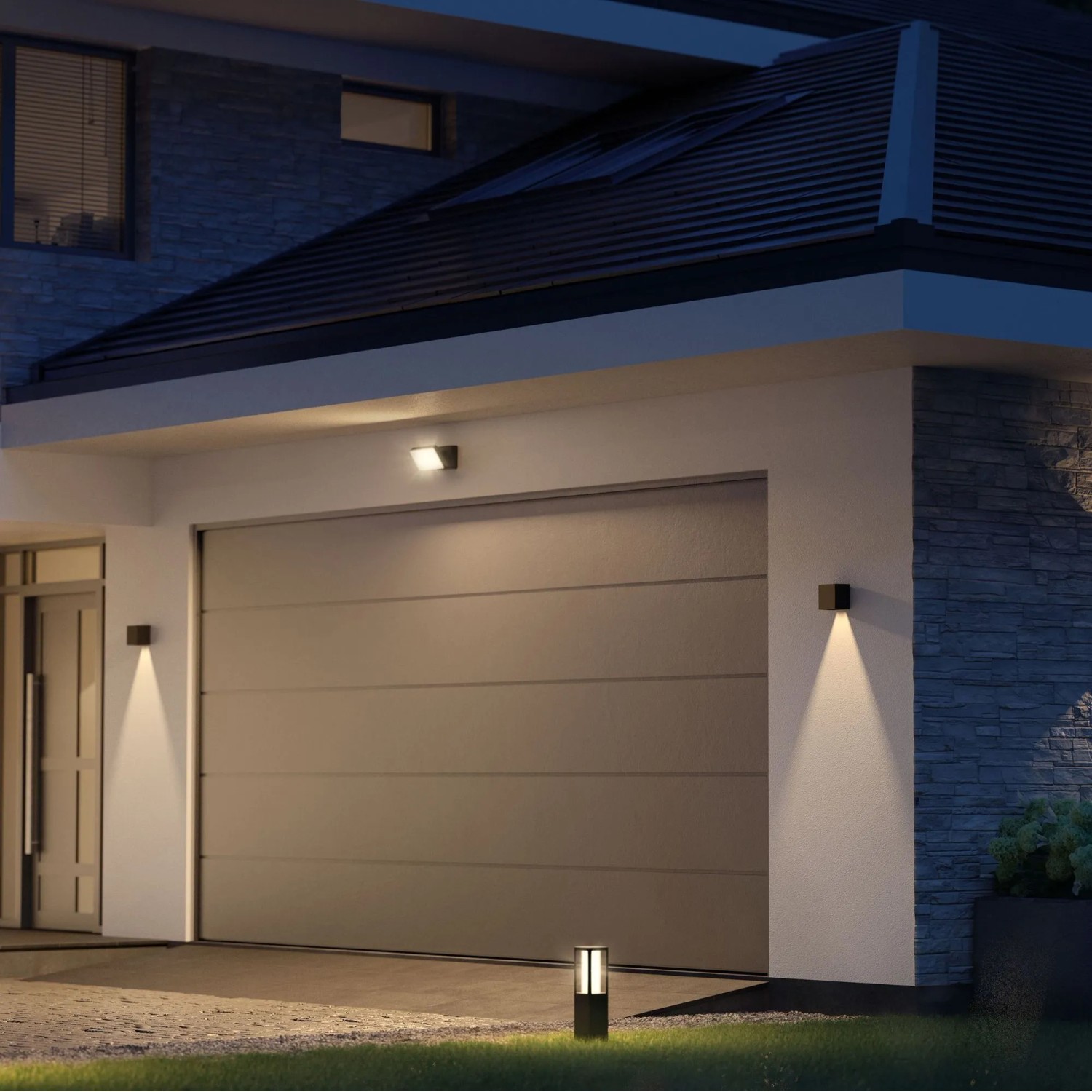 Moderne Philips Hue Resonate LED-Außenwandleuchte in Schwarz mit Lichtkegel an Hauswand.