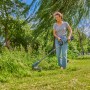 Frau nutzt Gardena Akku-Trimmer PowerTrim 30/18V im Garten für präzise Rasenkanten.