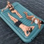 Bestway Hydro Force Floating Platform Sun Soaker mit drei Personen auf dem Wasser.
