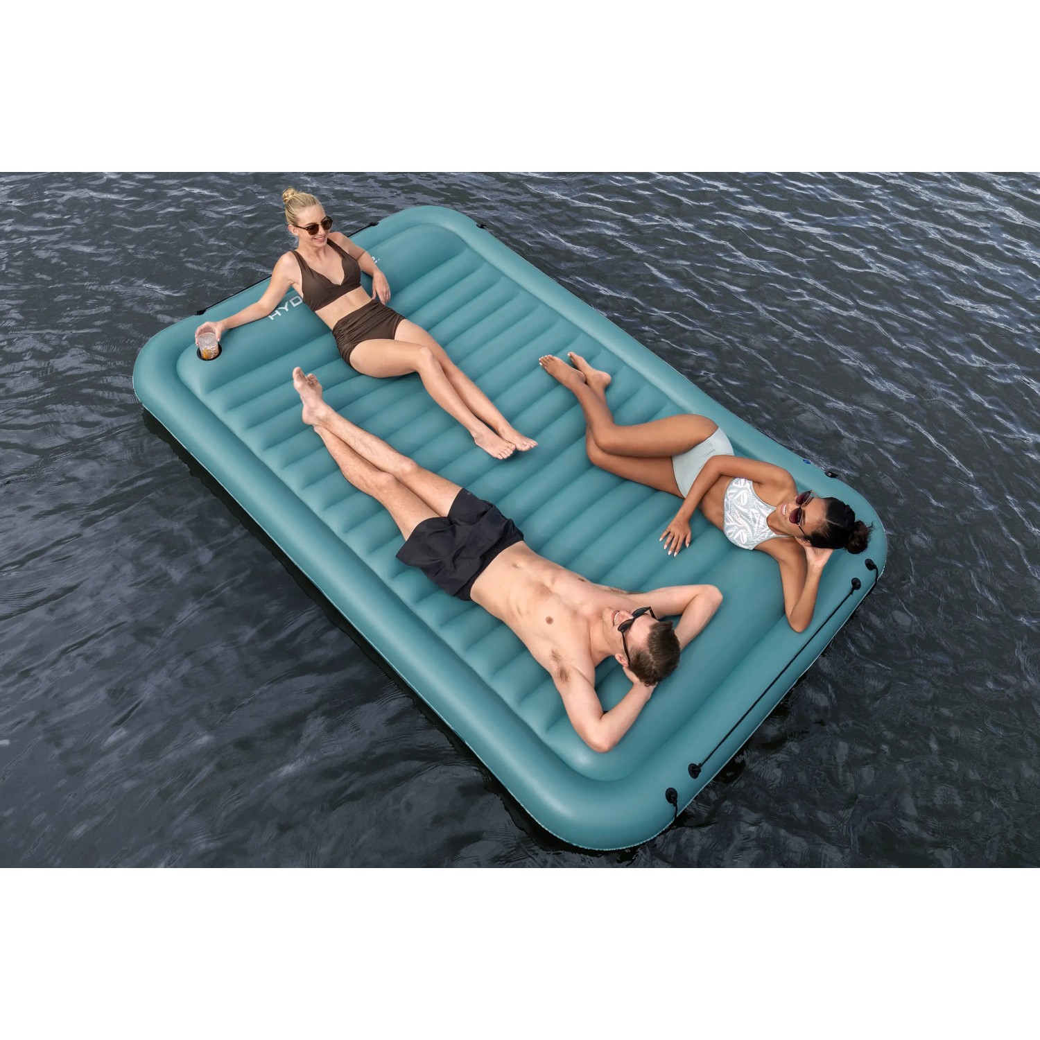 Bestway Hydro Force Floating Platform Sun Soaker mit drei Personen auf dem Wasser.