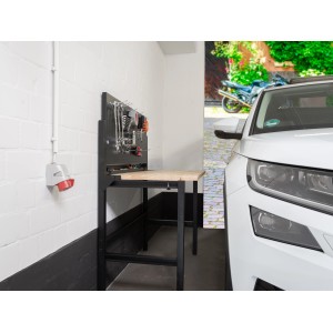 rikta Klappwerkbank, aufgeklappt in Garage mit Werkzeug an Lochwand. Platzsparende Werkbank.