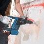 Bosch Professional GBH 18V-26F Akku-Bohrhammer mit Zubehör beim Bohren in eine Wand.