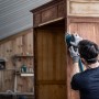 Mann schleift Schrank mit Deltaschleifer und Bosch Expert Schleifblatt K240.