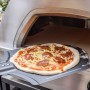 Buschbeck Pizzaofen X1 mit Pizza auf Schieber vor dem Ofen. Gas- und Holzbetrieb möglich.