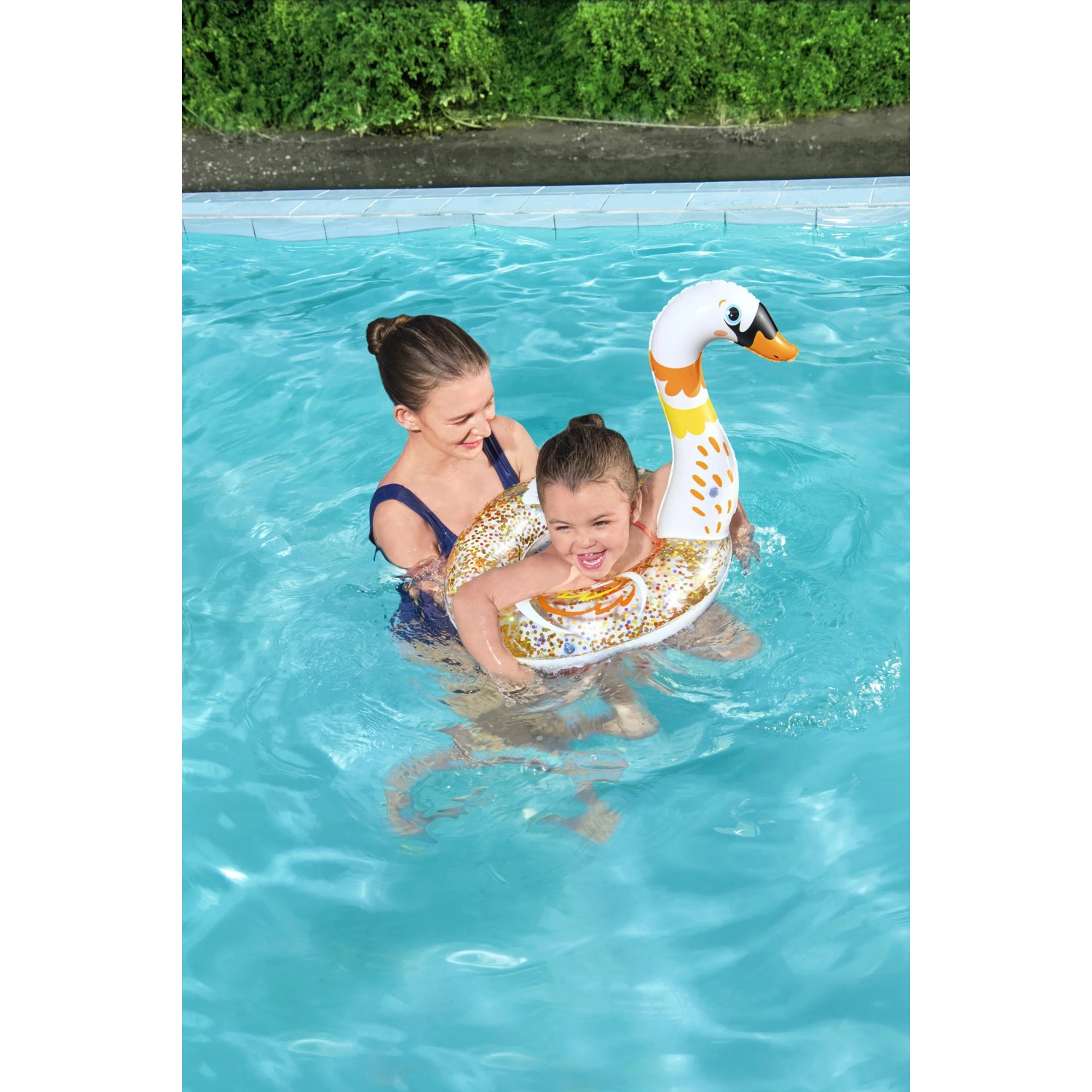 Kind mit Bestway Schwimmring (Schwan) im Pool, glitzernd. Badespaß!