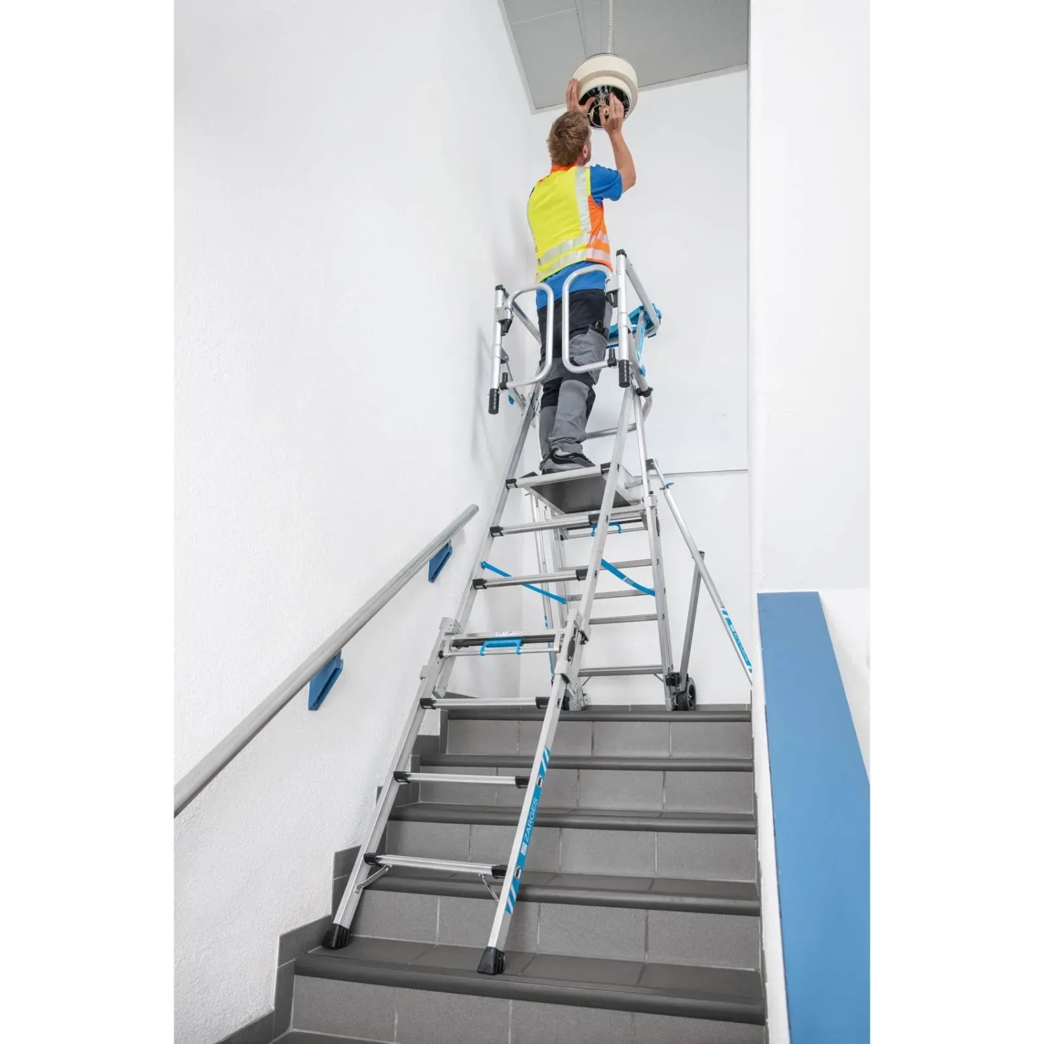 Zarges Teleskop-Plattformleiter ZAP Masterflex Plus auf Treppe mit Arbeiter bei Montagearbeiten.
