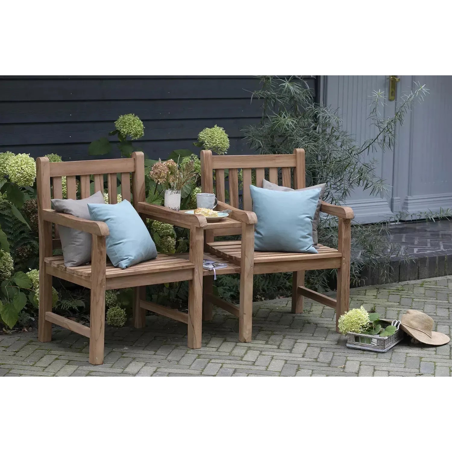GarWoh Gartenbank Feierabend aus Teakholz mit Armlehnen und Kissen im Garten.