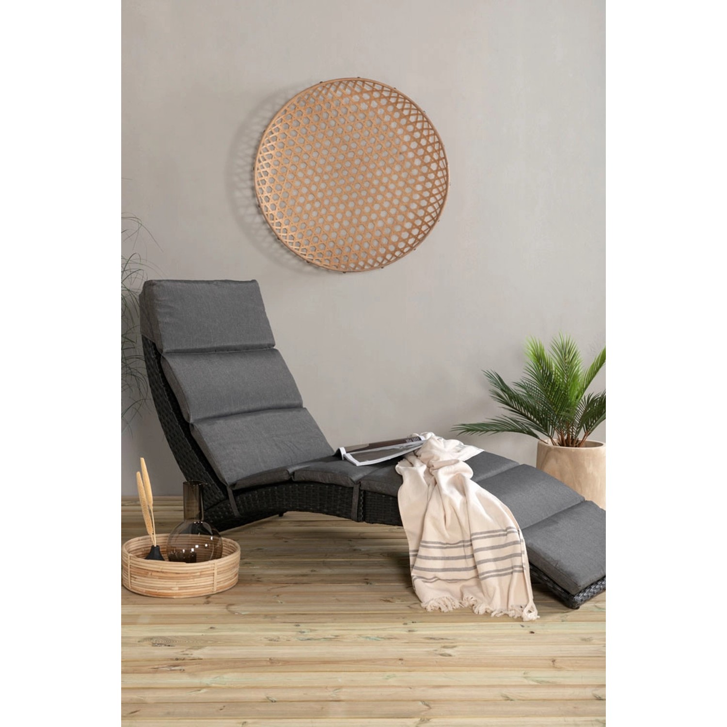 Schwarze ebuy24 Archie Sonnenliege aus Rattan mit grauen Polstern und Deko.