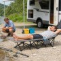 Sekey Feldbett mit Matratze als Campingbett im Einsatz am Fluss, Person liegt entspannt.