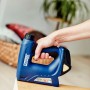 Rapid Akku-Tacker BTX530 in Aktion: Hand tackert Material mit blauem Tacker.