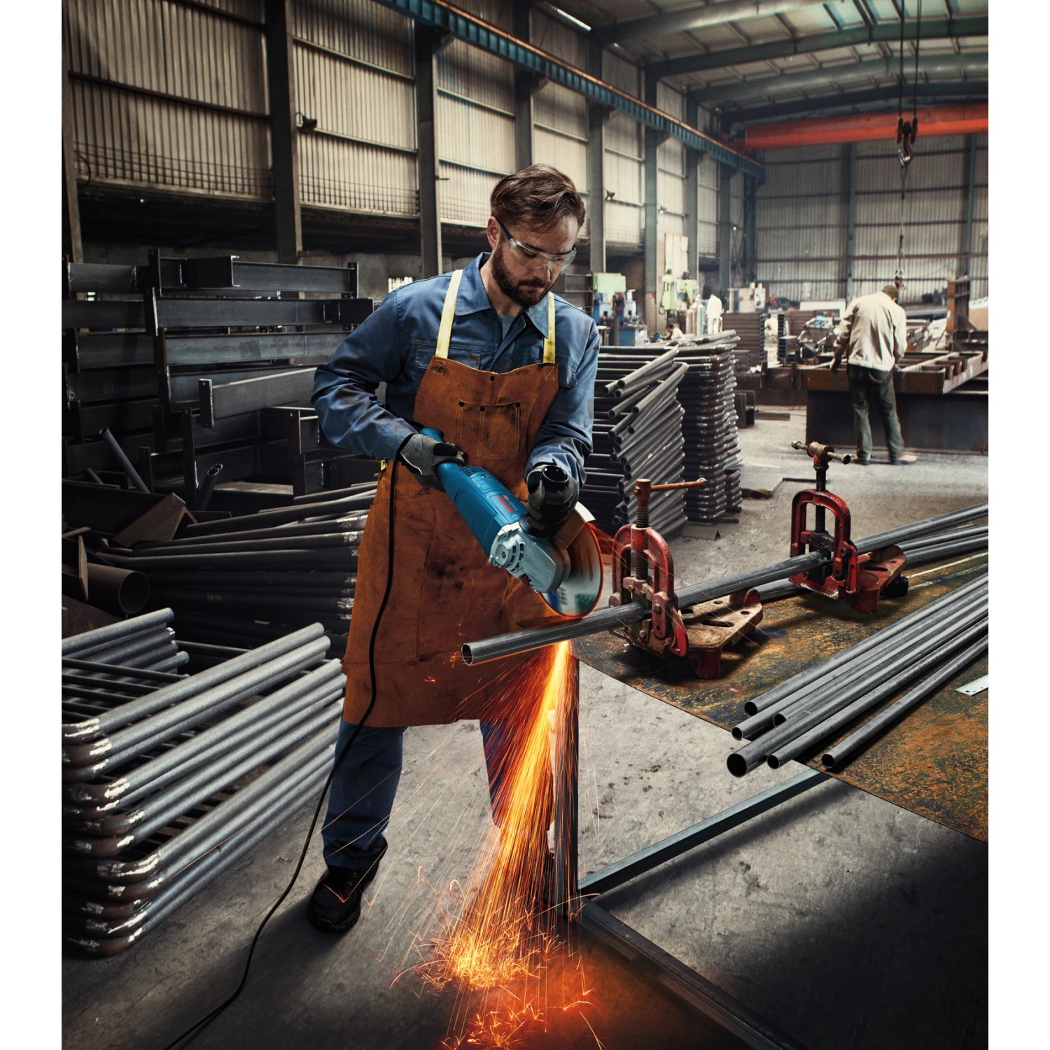 Mann schneidet Metall mit Bosch Professional Winkelschleifer GWS 22-180 J.